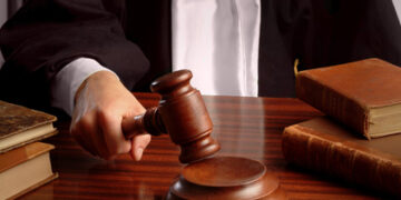 A judge hand striking a gavel over a table